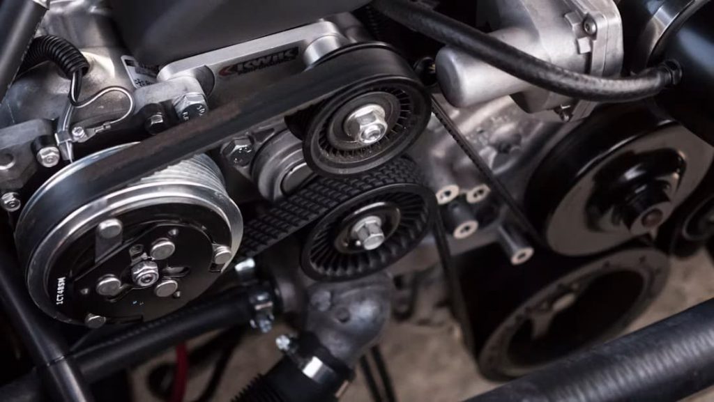 Close-up of a car engine bay with serpentine belt and pulleys