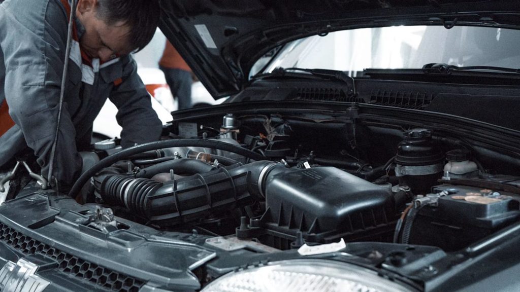 Mechanic inspecting a car engine bay